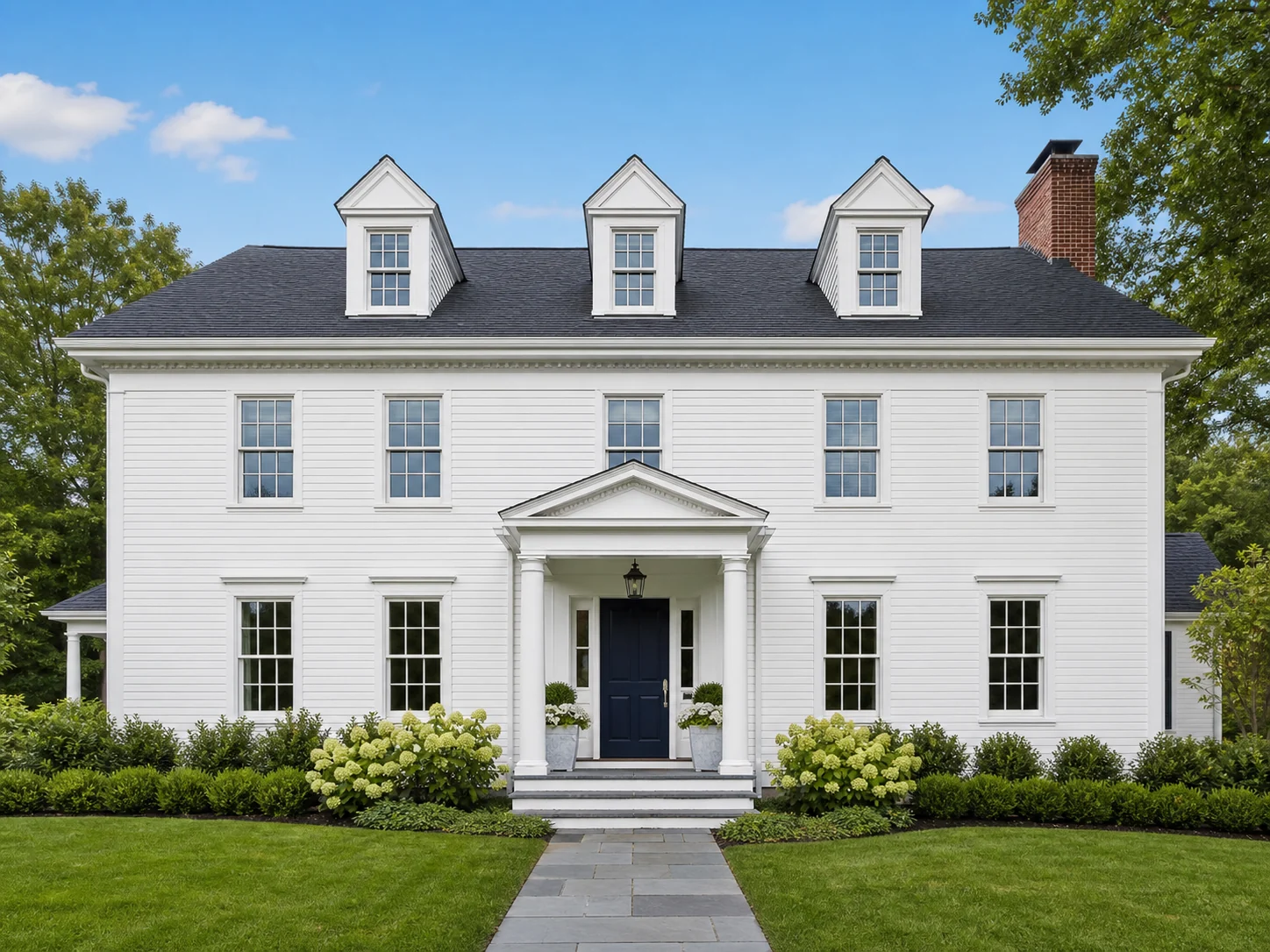 Freshly painted white home exterior with a deep navy front door